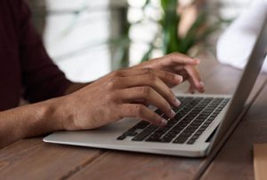 person using macbook 300x203.jpg